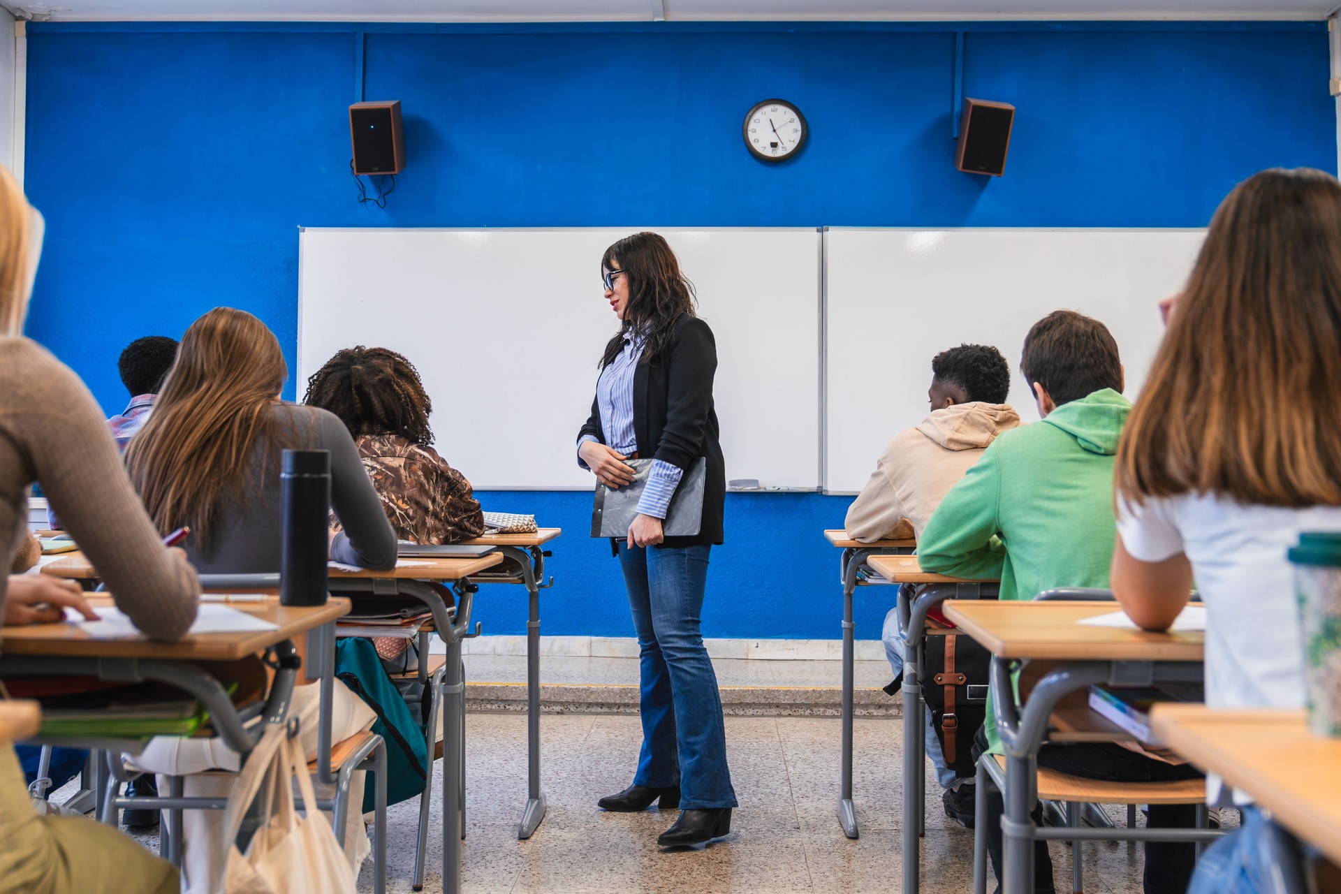 High school teacher giving lesson to students in classroom