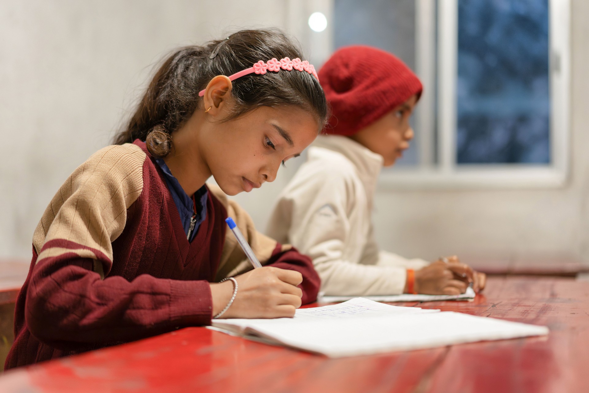 Indian Children Studying in Classroom, Young Girl Wearing School Uniform Writing on a Notepad, Learning and Education Concept